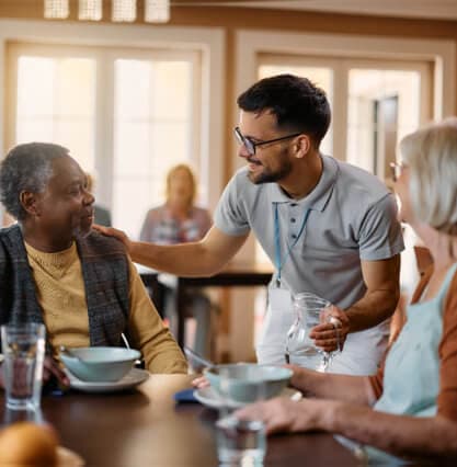 elderly couple talk to caretaker