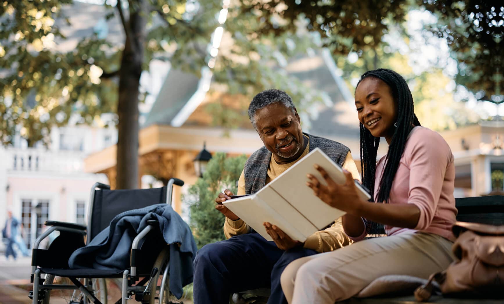 caretaker read a book to elderly man